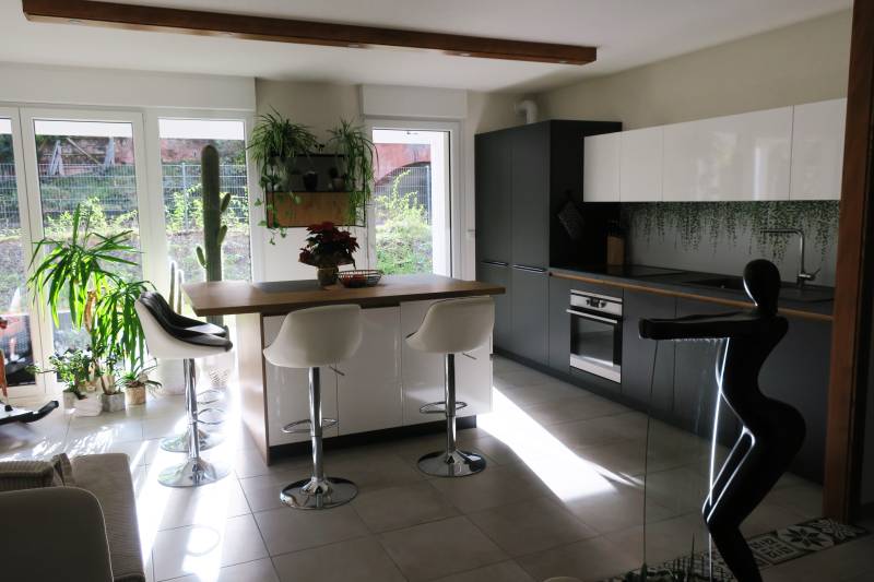 Mise en place d'une cuisine noir mat et blanc sans poignée avec l'intégration d'une crédence florale à Sarrebourg près de Saverne